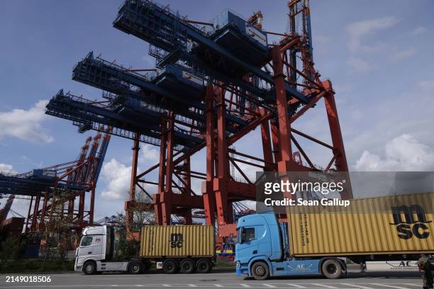Truck drives past container cranes at Hamburg Port on April 17, 2024 in Hamburg, Germany. The International Monetary Fund has reduced its prognosis...