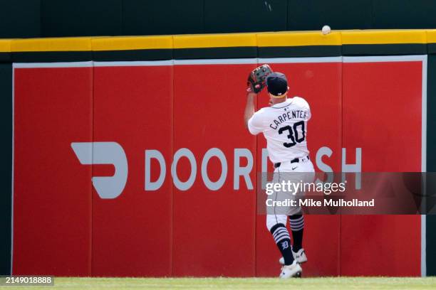 Ball hit by Adolis Garcia of the Texas Rangers lands atop the outfield fence as Kerry Carpenter of the Detroit Tigers races after it during the sixth...