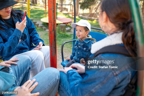 child's amusement on park carousel attracts smiles - peel park stock pictures, royalty-free photos & images