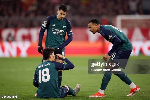 Takehiro Tomiyasu reacts and points to his eye, with Gabriel Martinelli and Gabriel of Arsenal during the UEFA Champions League quarter-final second...