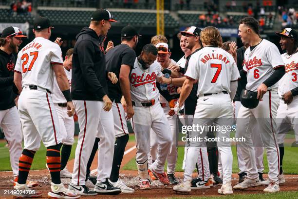 Cedric Mullins of the Baltimore Orioles celebrates with teammates at home plate after hitting the game-winning two-run home run against the Minnesota...