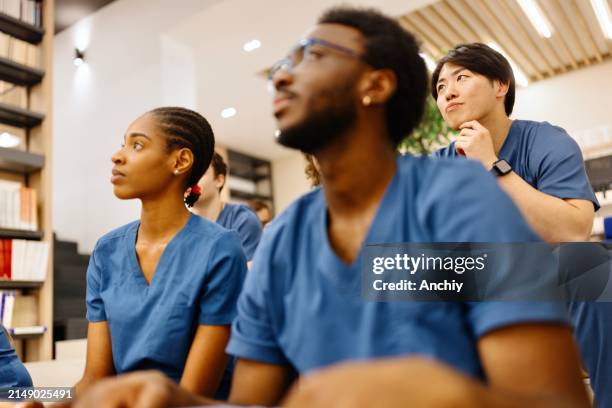 gemischtrassige studenten hören ihrem professor zu - medizinische fakultät stock-fotos und bilder