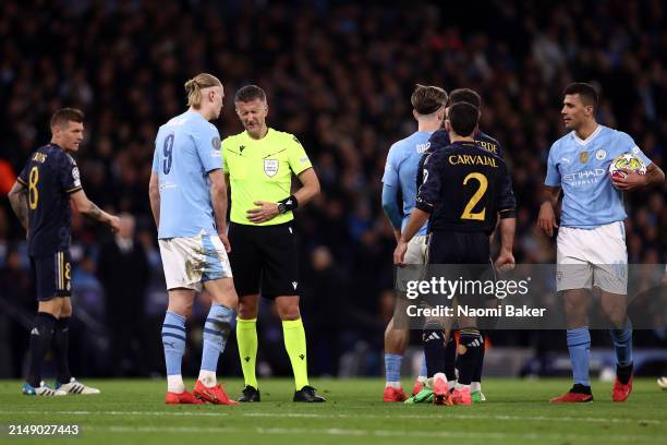 Referee Daniele Orsato reacts alongside Erling Haaland of Manchester City after he is hit in the stomach with the ball during the UEFA Champions...