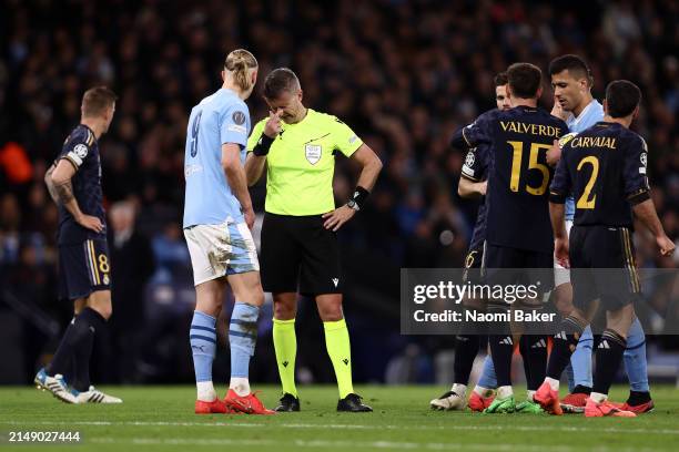 Referee Daniele Orsato reacts alongside Erling Haaland of Manchester City after he is hit in the stomach with the ball during the UEFA Champions...