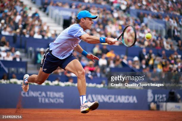 Alex de Minaur of Australia returns a ball against Rafael Nadal of Spain in the second round during day three of the Barcelona Open Banc Sabadell at...