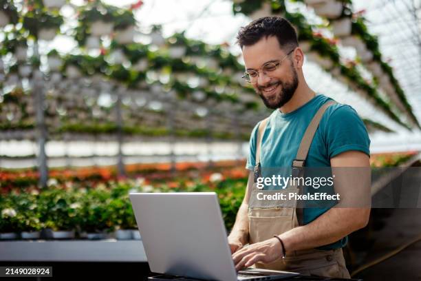 business owner with laptop in greenhouse - environmental issues stock pictures, royalty-free photos & images