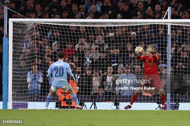 Andriy Lunin of Real Madrid saves the second penalty from Bernardo Silva of Manchester City in the penalty shoot out during the UEFA Champions League...
