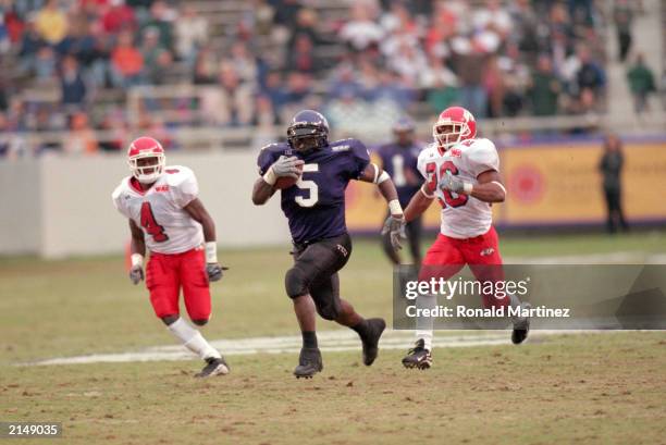 LaDainian Tomlinson of the Texas Christian University carries the ball as he is chased by Bryce McGill and Tierre Sans of Fresno State during a game...