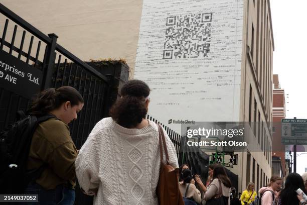 Taylor Swift fans gather outside a building where a mural featuring a large QR code was being painted to promote Swift's latest album, "The Tortured...