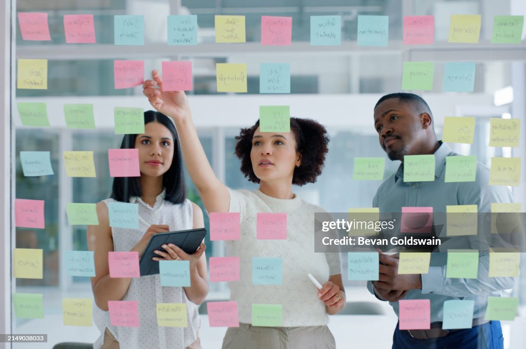 Geschäftsleute, Tablet und Haftnotizen auf Glaswand im Büro zum Planen, Diskutieren und Brainstorming. Teamwork, Mann und Frau mit kreativen Ideen, Strategie und Eventplaner in Zusammenarbeit