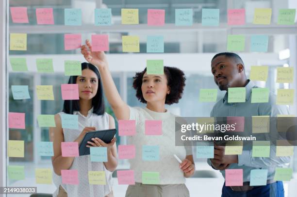 gente de negocios, tableta y notas adhesivas en la pared de vidrio de la oficina para la planificación, la discusión y la lluvia de ideas. trabajo en equipo, hombre y mujer con ideas creativas, estrategia y organizador de eventos en colaboración - cristalino fotografías e imágenes de stock