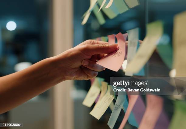 hand, business and sticky note with planning, ideas and creativity for novel and schedule for writing. person, closeup or author with brainstorming or research for project, paper or story development - redacteur stockfoto's en -beelden