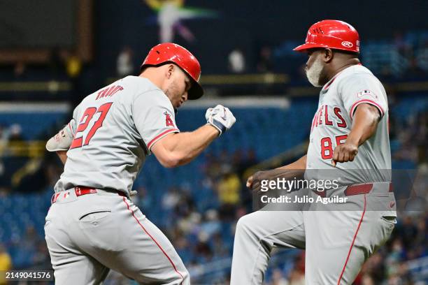 Mike Trout celebrates with third base coach Eric Young Sr. #85 of the Los Angeles Angels after hitting a home run in the first inning against the...