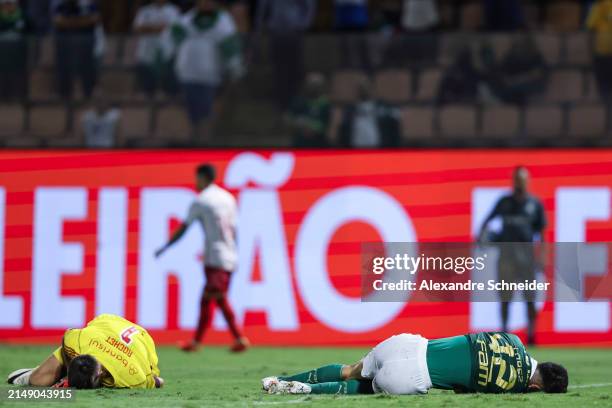 Sergio Rochet of Internacional and Jose Lopez of Palmeiras react on the ground after colliding during a match between Palmeiras and Internacional as...