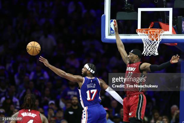 Buddy Hield of the Philadelphia 76ers passes the ball past Bam Adebayo of the Miami Heat during the fourth quarter of the Eastern Conference Play-In...