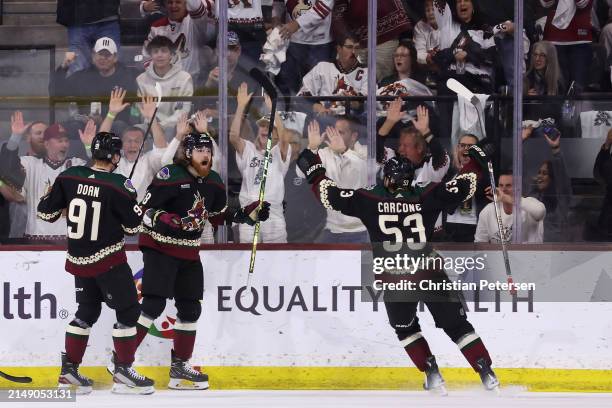 Liam O'Brien of the Arizona Coyotes celebrates with Josh Doan and Michael Carcone after scoring a goal against the Edmonton Oilers during the first...