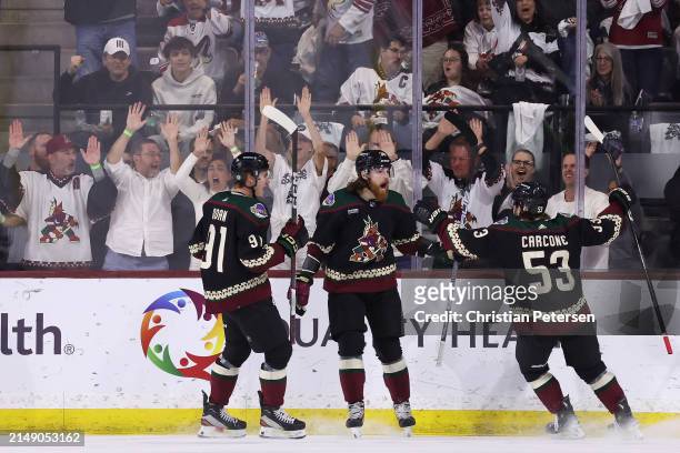 Liam O'Brien of the Arizona Coyotes celebrates with Josh Doan and Michael Carcone after scoring a goal against the Edmonton Oilers during the first...