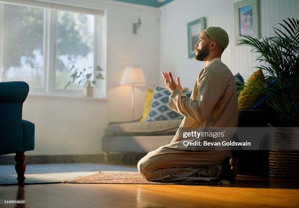 Anbetung, Gott und muslimischer Mann beten im Haus mit Glauben, Dankbarkeit oder Spiritualität, islamisch, Religion oder Person mit Duo-, Dua- oder Gebetshänden im Wohnzimmer für Dank, Lobpreis oder Respekt für Allah