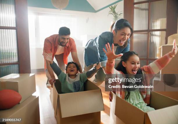 happy family, parents and children in boxes in new home or playing game, property investment and real estate. excited, people and moving day with fresh start and celebration for bond payment on house - home ownership stock pictures, royalty-free photos & images