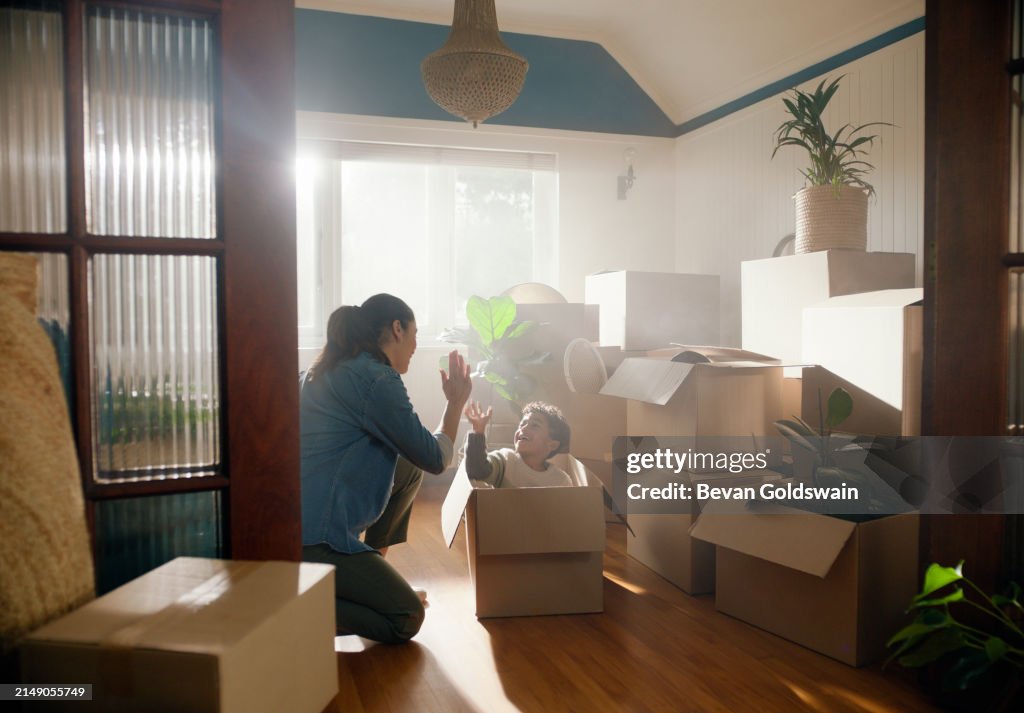 Glückliche Familie, Sohn und Mutter oder High Five im neuen Zuhause mit Boxen, Feier und Immobilieninvestition. Immobilie, Frau und Kind mit Umzugstag, Neuanfang oder Erfolg mit Kautionszahlung auf Haus
