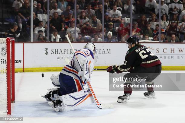 Matias Maccelli of the Arizona Coyotes shoots to score a goal past goaltender Calvin Pickard of the Edmonton Oilers during the second period of the...