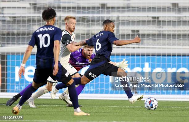 Jacori Hayes of North Carolina FC is defended by Jacob Evans and Alex Sutton of Carolina Core FC during the U.S. Open Cup third round game between...