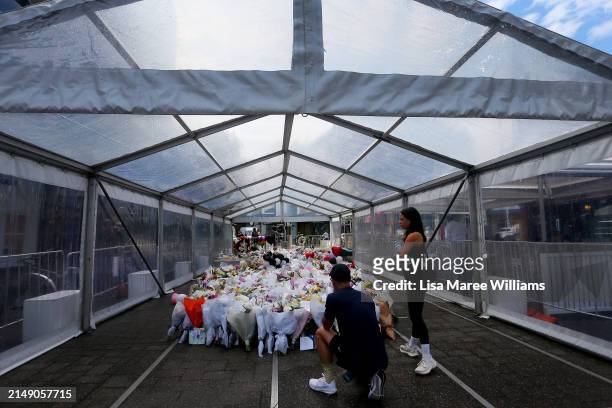 Members of the public lay flower tributes at the edge of Westfield Bondi Junction during a day of reflection on April 18, 2024 in Bondi Junction,...