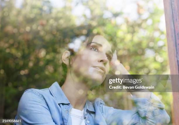 zuhause, denken und frau am fenster mit erinnerung, idee oder einsicht für planung, vision oder verstand. reflexion, glas und weibliche person in wohnung mit psychischer gesundheit, erinnern oder traurig am wochenendmorgen - nachdenken stock-fotos und bilder