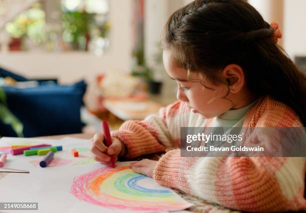 ragazza, bambino e disegno con arcobaleno in casa per lo sviluppo, l'apprendimento e la creatività con carta alla scrivania. bambino, schizzo e pastello per abilità, arte e colore con motivo per il progresso nella casa di famiglia - colorare foto e immagini stock