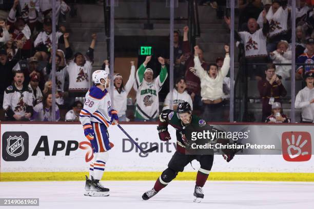 Dylan Guenther of the Arizona Coyotes celebrates with Sean Durzi after scoring a a power-play goal against the Edmonton Oilers during the third...