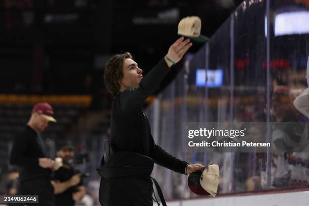 Clayton Keller of the Arizona Coyotes throws hats to fans following the NHL game against the Edmonton Oilers at Mullett Arena on April 17, 2024 in...