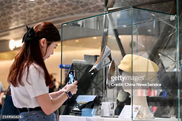 Women takes a photo of shoes, bags and hats used by Princess Diana displayed at the media preview ahead of the auction of the Princess Diana's...