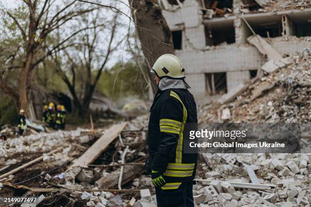 Rescuers conduct search and rescue operation at object of social infrastructure destroyed as result of Russian missile attack on April 17, 2024 in...