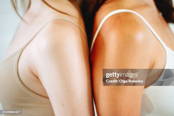 different skin and body. women shoulders with white and bronze skin - shoulder stock pictures, royalty-free photos & images