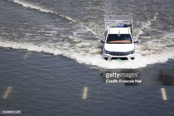Car drives on a flooded highway on April 18, 2024 in Dubai, United Arab Emirates. Atypically heavy rains in the UAE on Monday and Tuesday caused...