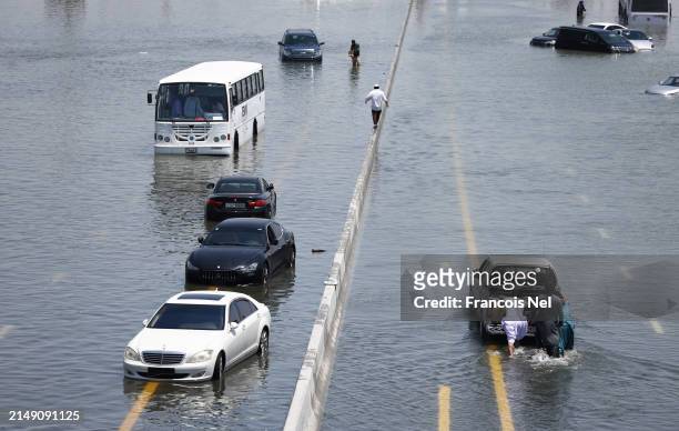 Abandoned vehicles on a flooded highway can be seen on April 18, 2024 in Dubai, United Arab Emirates. Atypically heavy rains in the UAE on Monday and...