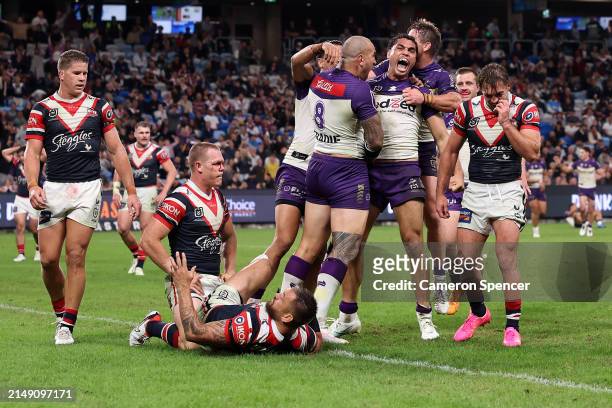 Xavier Coates of the Storm celebrates with team mates after scoring a try during the round seven NRL match between Sydney Roosters and Melbourne...