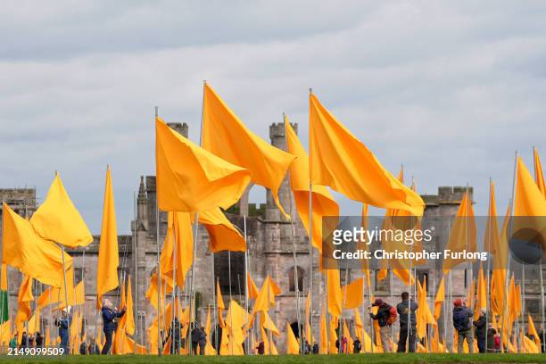 Volunteers hoist over 500 yellow flags flying in the grounds of Lowther Castle in the Lake District on April 18, 2024 in Penrith, England. County...