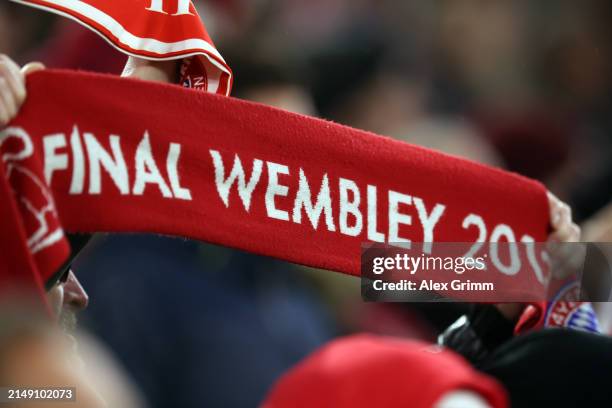 Fan holds up a scarf from the 2013 Champions League final at Wembley stadium during the UEFA Champions League quarter-final second leg match between...