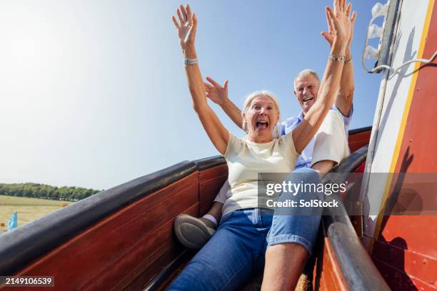 senior couple sliding down a helter skelter - fun stock pictures, royalty-free photos & images