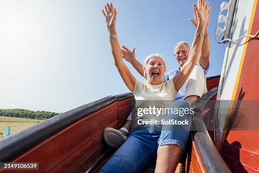 Senior Couple Sliding down a Helter Skelter Senior Couple Sliding down a Helter Skelter