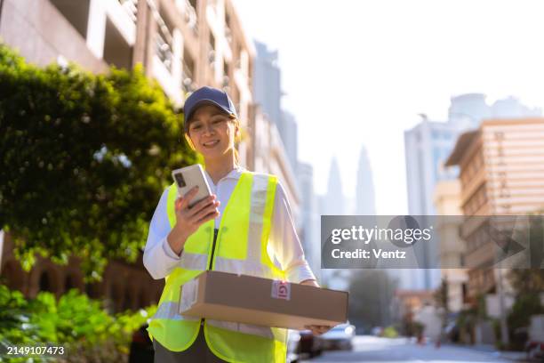 consegna: lavoratrice asiatica che trova la posizione - postino foto e immagini stock