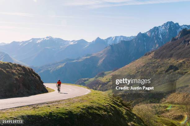 a beautiful morning landscape view of a mature cyclist on a bend on the col du soulor in the french pyrenees - col de montagne photos et images de collection