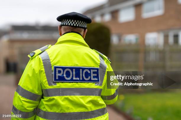 a policeman walking away from an elderly person's home. - british police stock-fotos und bilder