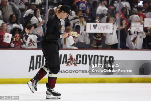 Josh Doan of the Arizona Coyotes signs hats for fans following the NHL game against the Edmonton Oilers at Mullett Arena on April 17, 2024 in Tempe,...