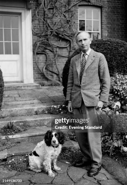 Secretary of State for Commonwealth Relations, Alec Douglas-Home poses with a cocker spaniel dog, London, April 3rd 1957.