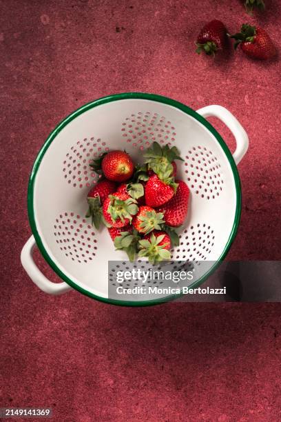fresh organic strawberries in ceramic colander - salatsieb stock-fotos und bilder