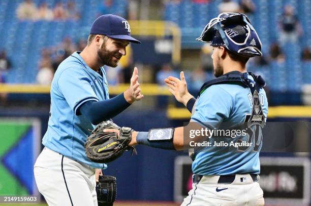 Colin Poche and René Pinto of the Tampa Bay Rays celebrate after defeating the Los Angeles Angels 2-1 at Tropicana Field on April 18, 2024 in St...