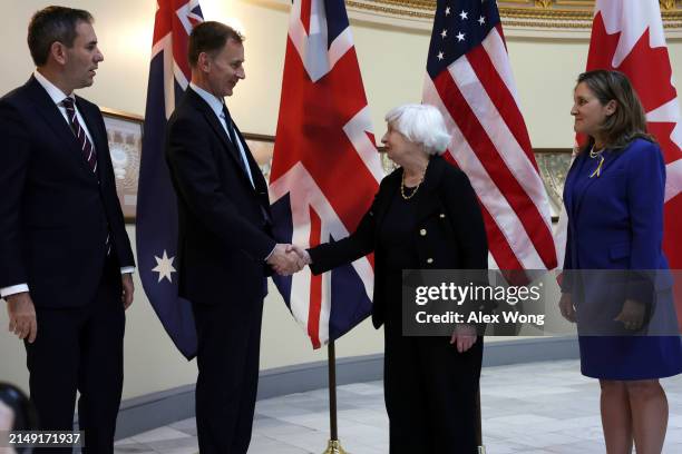 Secretary of the Treasury Janet Yellen shakes hands with Chancellor of the Exchequer Jeremy Hunt of the United Kingdom as Treasurer Jim Chalmers of...