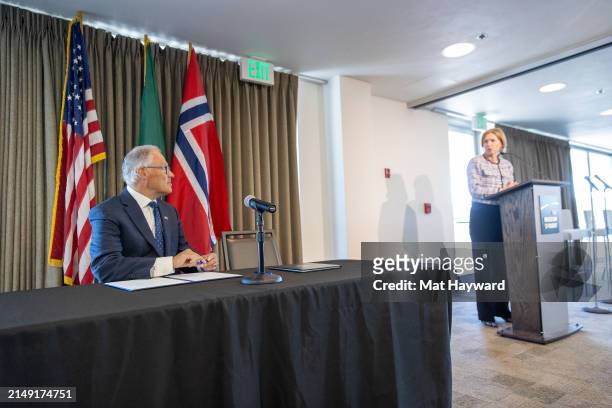 Washington Governor Jay Inslee listens to Norway's ambassador to the United States Anniken Krutnes before signing a joint statement on climate...